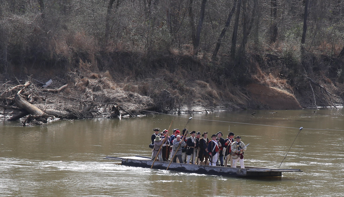 Re-enactment depicting a boat of colonial-era soldiers crossing the Dan River